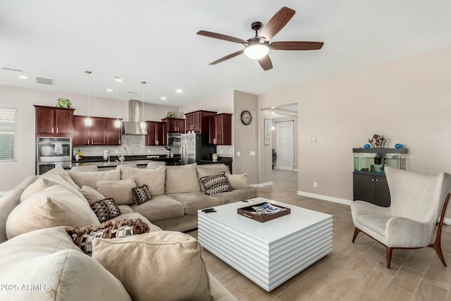 living room featuring ceiling fan and sink