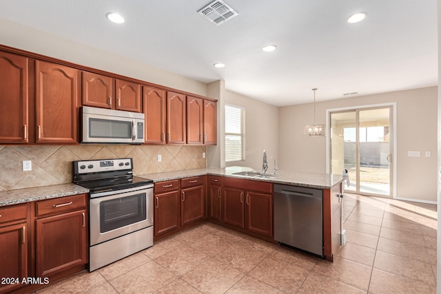 kitchen featuring hanging light fixtures, kitchen peninsula, plenty of natural light, and stainless steel appliances