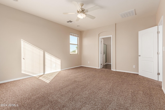 empty room featuring ceiling fan and carpet