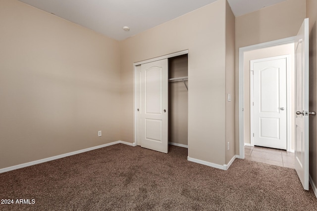 unfurnished bedroom featuring carpet flooring and a closet