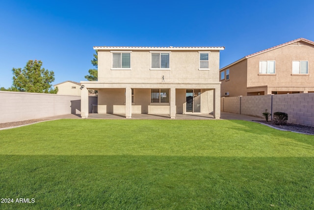 back of house with a lawn and a patio area