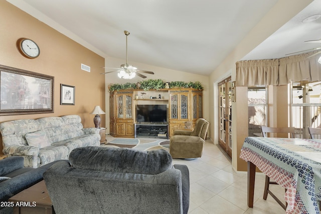 living area with a ceiling fan, lofted ceiling, and light tile patterned floors