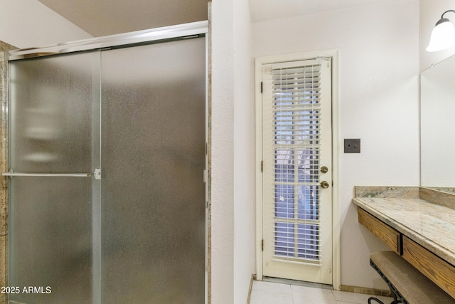 full bath featuring an enclosed shower, tile patterned flooring, and vanity