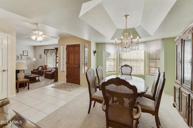 dining room featuring light tile patterned floors, a textured ceiling, a notable chandelier, light colored carpet, and a tray ceiling