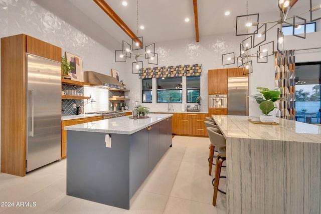 kitchen featuring brown cabinetry, a spacious island, modern cabinets, appliances with stainless steel finishes, and backsplash