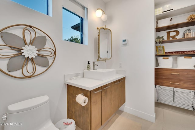 bathroom featuring baseboards, vanity, toilet, and tile patterned floors