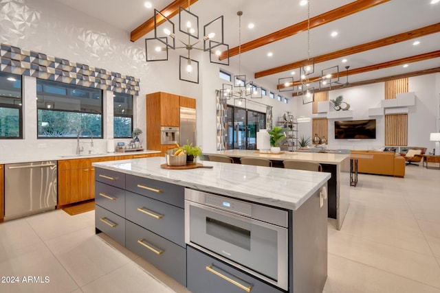 kitchen featuring a spacious island, a sink, stainless steel dishwasher, and modern cabinets