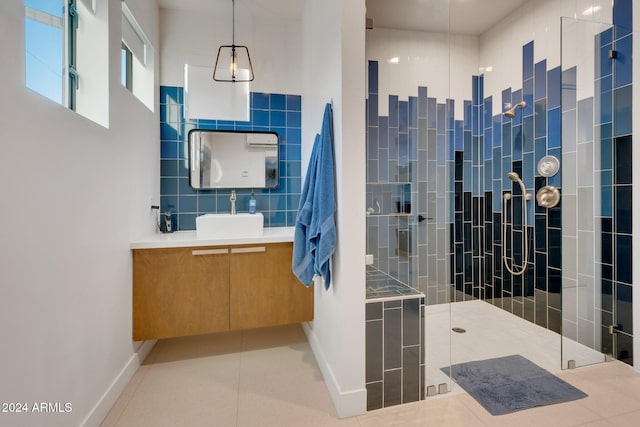 full bath featuring decorative backsplash, tile patterned floors, vanity, a walk in shower, and tile walls