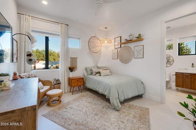 bedroom featuring light tile patterned floors, recessed lighting, baseboards, and ensuite bathroom