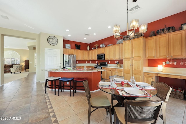 tiled dining room featuring an inviting chandelier