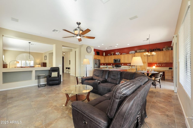 living room with ceiling fan with notable chandelier