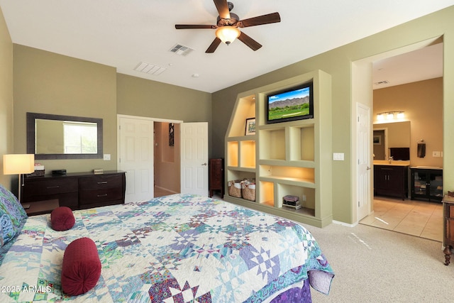 carpeted bedroom with ceiling fan and ensuite bath