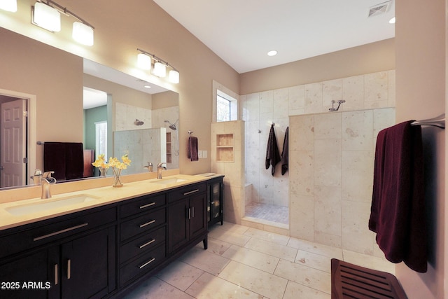 bathroom with tile patterned floors, tiled shower, and vanity