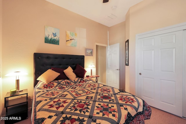 carpeted bedroom with ceiling fan and a closet