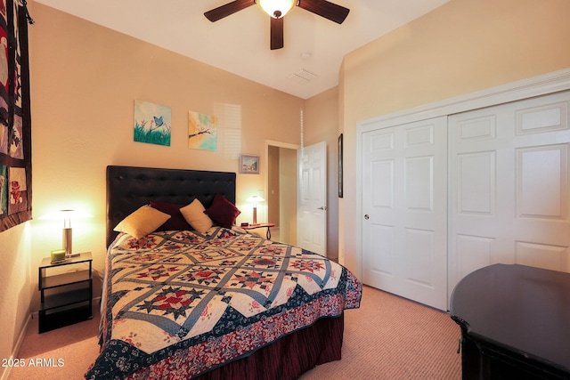 carpeted bedroom with ceiling fan, a closet, and vaulted ceiling