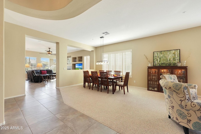 carpeted dining area with ceiling fan and plenty of natural light