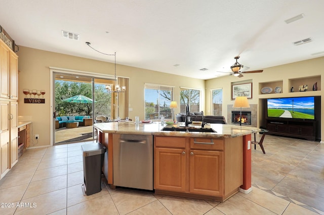 kitchen with a fireplace, pendant lighting, sink, a kitchen island with sink, and ceiling fan with notable chandelier