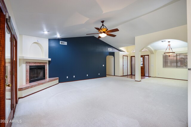 unfurnished living room featuring carpet, a tile fireplace, ceiling fan, and lofted ceiling