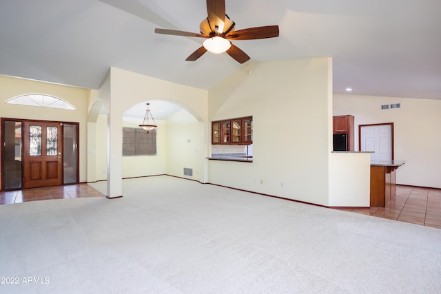 unfurnished living room featuring carpet flooring, high vaulted ceiling, and ceiling fan