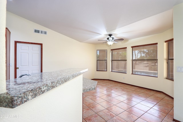 kitchen with vaulted ceiling, ceiling fan, and light tile floors