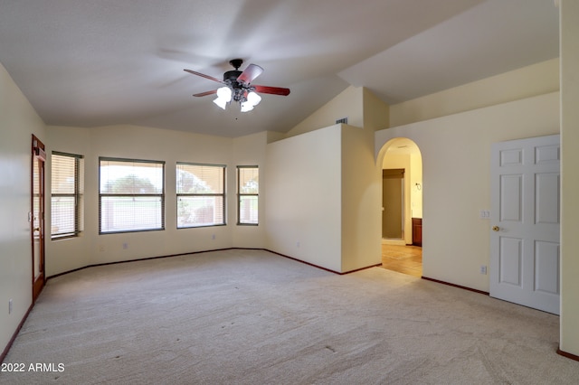 empty room featuring light colored carpet, ceiling fan, and lofted ceiling