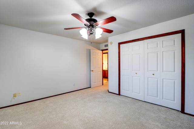 unfurnished bedroom with light carpet, a closet, and ceiling fan