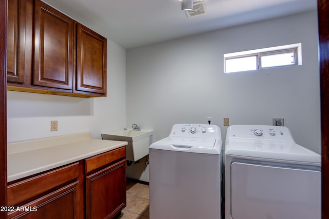 washroom featuring washing machine and dryer, cabinets, light tile flooring, electric dryer hookup, and sink