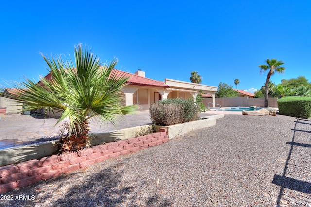 view of side of home featuring a patio and a fenced in pool