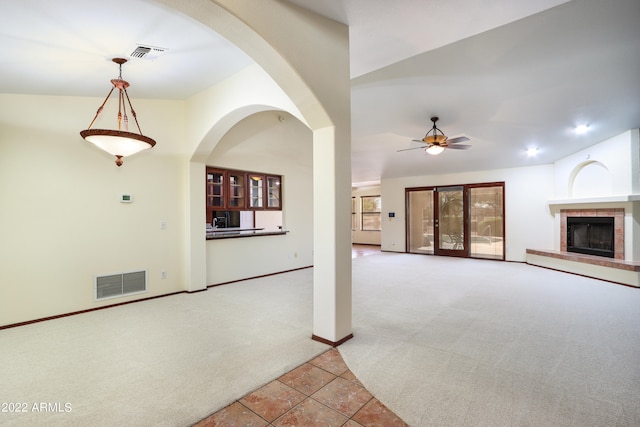 unfurnished living room featuring carpet flooring, ceiling fan, and vaulted ceiling