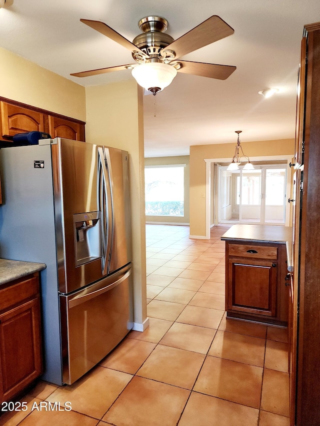 9939 W Ironwood Dr, Sun City, AZ 85351 - kitchen featuring stainless steel fridge, ceiling fan, light tile patterned flooring, decorative light fixtures, and plenty of natural light