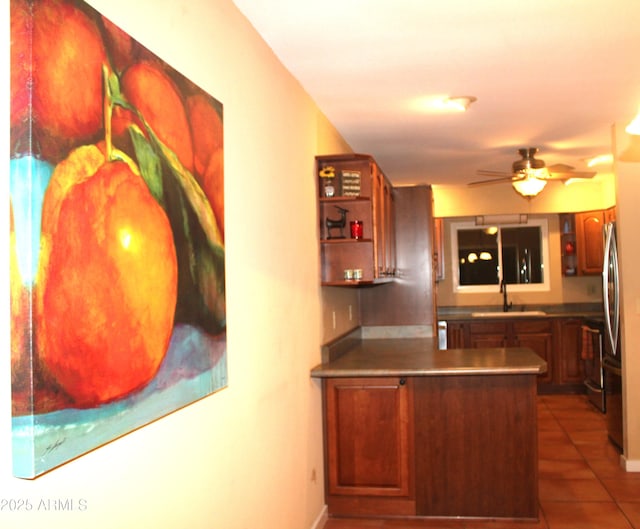 9939 W Ironwood Dr, Sun City, AZ 85351 - kitchen with tile patterned flooring, ceiling fan, a peninsula, open shelves, and freestanding refrigerator