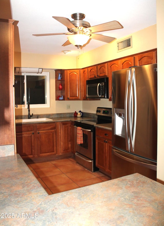 9939 W Ironwood Dr, Sun City, AZ 85351 - kitchen with stainless steel appliances, light tile patterned floors, a ceiling fan, brown cabinets, and open shelves