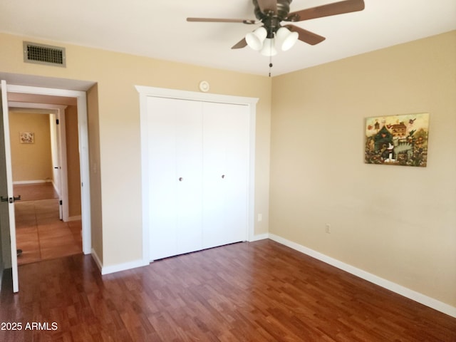 9939 W Ironwood Dr, Sun City, AZ 85351 - unfurnished bedroom featuring dark wood-type flooring, a closet, and ceiling fan