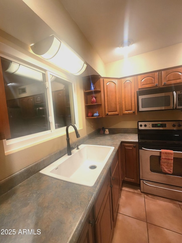 9939 W Ironwood Dr, Sun City, AZ 85351 - kitchen featuring appliances with stainless steel finishes, brown cabinetry, open shelves, and light tile patterned floors