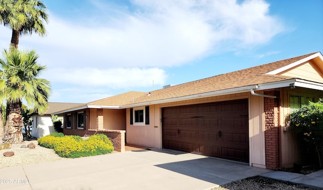 9939 W Ironwood Dr, Sun City, AZ 85351 - ranch-style home with an attached garage, driveway, roof with shingles, and stone siding