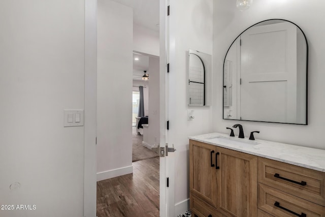 bathroom with wood-type flooring, vanity, and ceiling fan