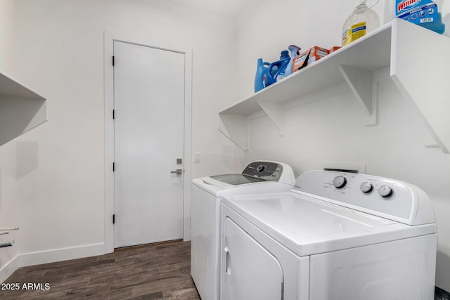 clothes washing area with washing machine and clothes dryer and dark hardwood / wood-style floors