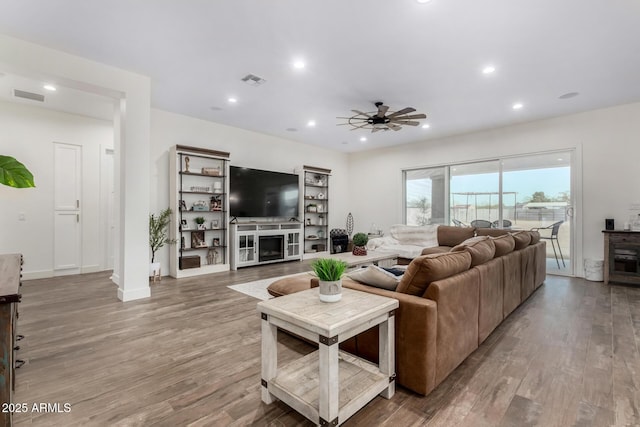 living room with wood-type flooring and ceiling fan