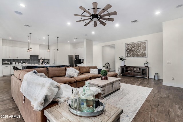 living room featuring ceiling fan and dark wood-type flooring