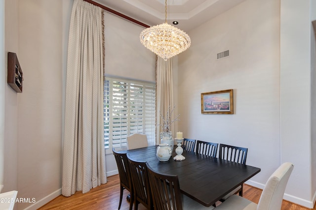 dining space with hardwood / wood-style flooring and an inviting chandelier