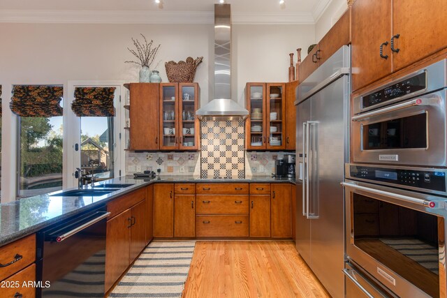 kitchen featuring backsplash, crown molding, light wood-type flooring, and appliances with stainless steel finishes