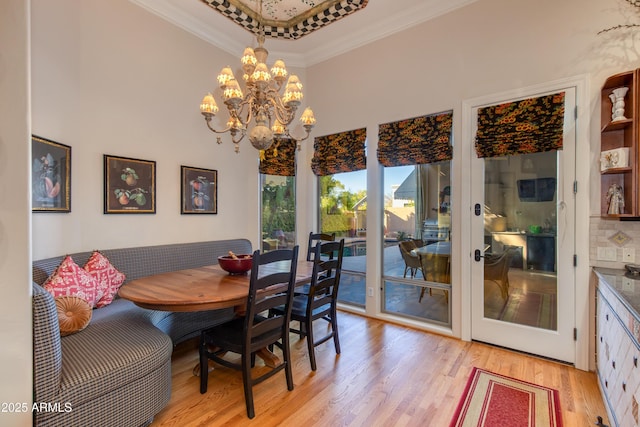 dining room with an inviting chandelier, light hardwood / wood-style flooring, and ornamental molding