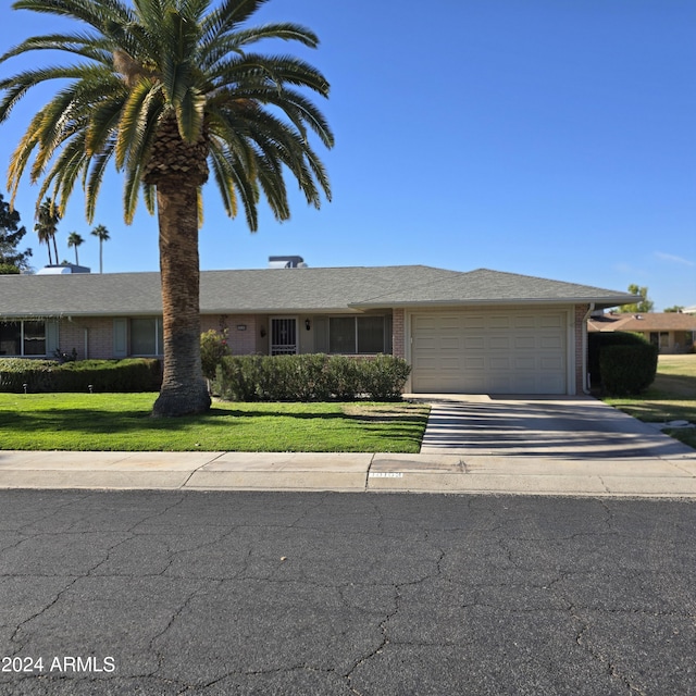 ranch-style home with a front yard and a garage