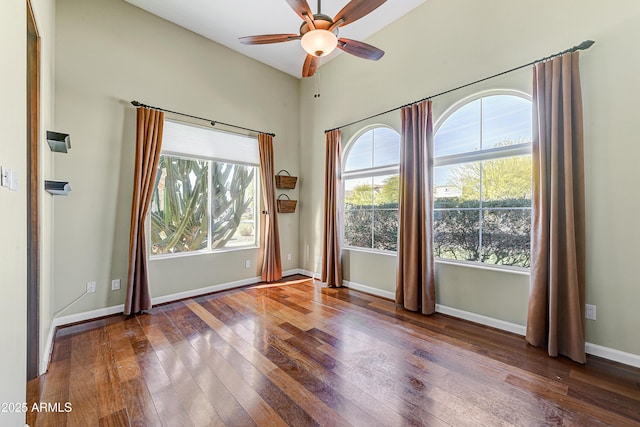 unfurnished room featuring hardwood / wood-style flooring, plenty of natural light, and baseboards