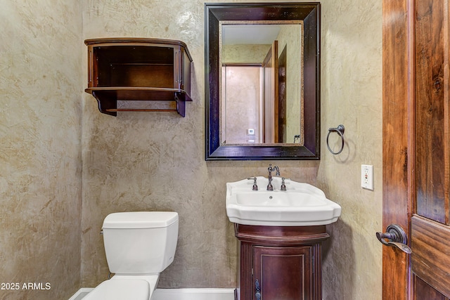 half bathroom with vanity and toilet