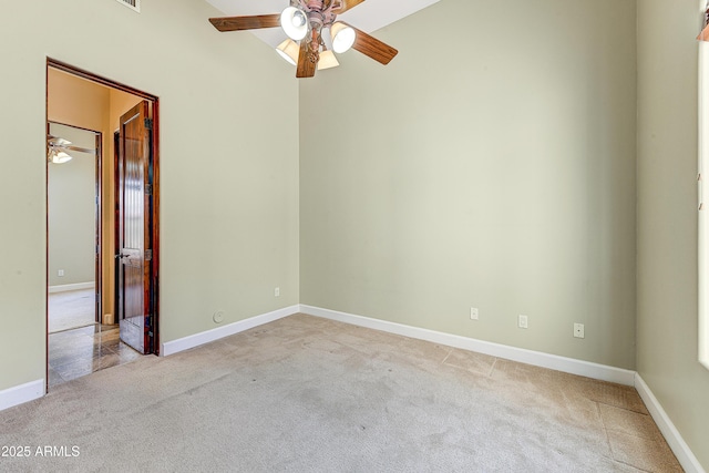 empty room featuring light colored carpet, ceiling fan, and baseboards