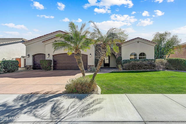 mediterranean / spanish house featuring an attached garage, a front lawn, concrete driveway, and stucco siding