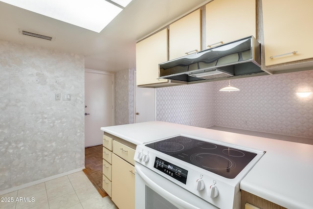 15608 N 57th Dr, Glendale, AZ 85306 - kitchen featuring white electric range oven, under cabinet range hood, light countertops, and cream cabinets