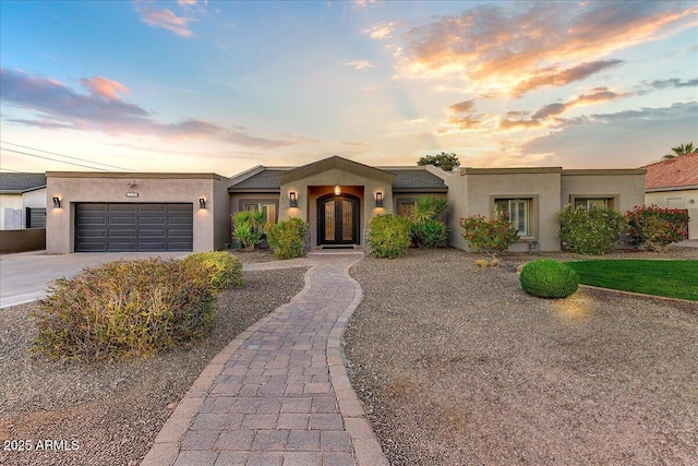 pueblo revival-style home featuring a garage