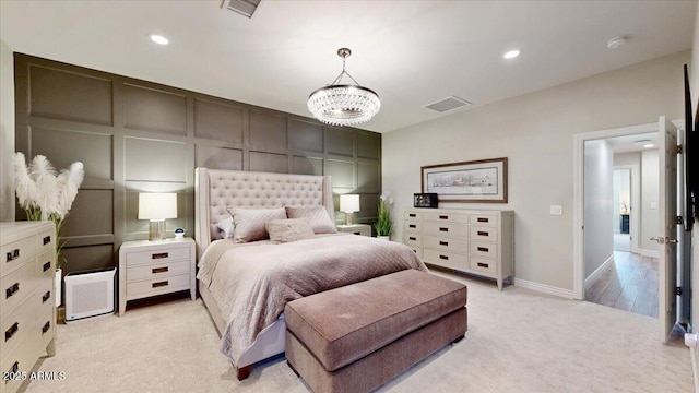 bedroom with light carpet and a notable chandelier